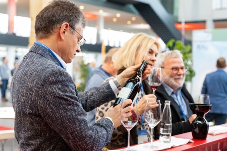 A man looking at a bottle of wine at the pre-event of the Eurovino in the Karlsruhe exhibition center