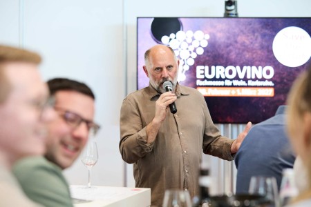 A speaker talks in front of an audience